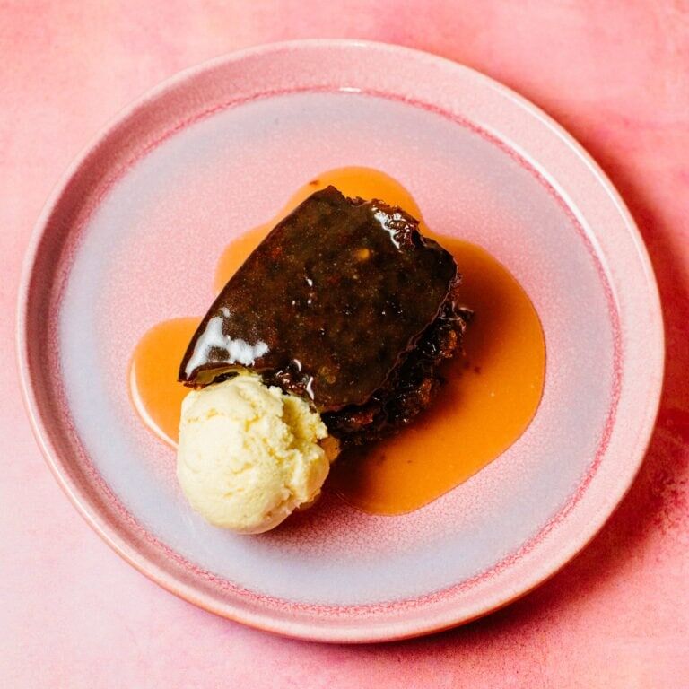 A rich, golden-brown pudding topped with glossy miso toffee sauce, served with a scoop of vanilla ice cream. Miso sticky toffee pudding recipe